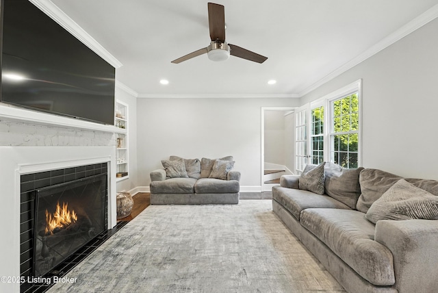 1724 Trevilian Way, Louisville, KY 40205 - living room with a warm lit fireplace, recessed lighting, wood finished floors, crown molding, and a ceiling fan