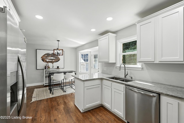 1724 Trevilian Way, Louisville, KY 40205 - kitchen with appliances with stainless steel finishes, white cabinets, dark wood-style floors, light stone counters, and a peninsula