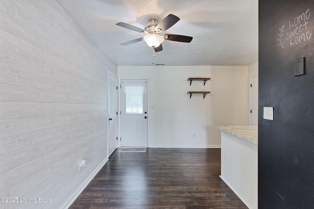 6604 Burlwood Dr, Louisville, KY 40229 - foyer entrance featuring wood walls, ceiling fan, a textured ceiling, and dark wood-style flooring