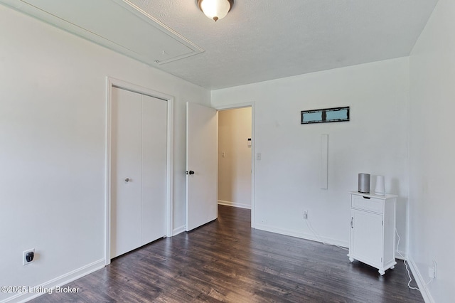 6604 Burlwood Dr, Louisville, KY 40229 - unfurnished bedroom with attic access, dark wood-style floors, a textured ceiling, and a closet