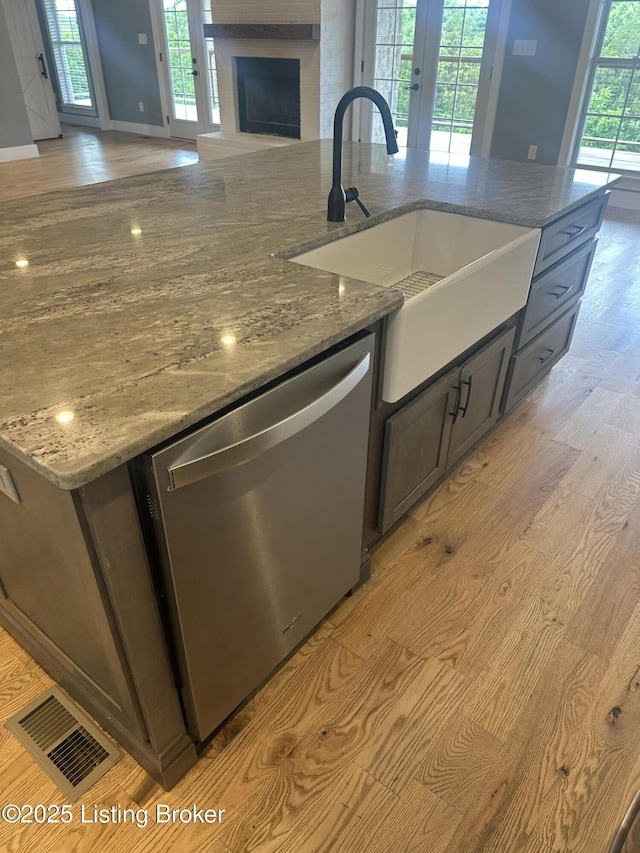 9530 Rocky Creek Ln, Louisville, KY 40299 - kitchen featuring dishwasher, open floor plan, light wood-style flooring, a center island with sink, and a fireplace
