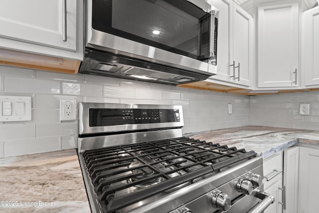 217 Shawnee Dr, Louisville, KY 40212 - kitchen featuring appliances with stainless steel finishes, white cabinetry, light stone countertops, and decorative backsplash