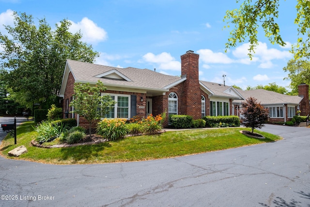 13702 Beowulf Ct, Louisville, KY 40299 - view of front of house featuring brick siding, asphalt driveway, a front yard, an attached garage, and a chimney