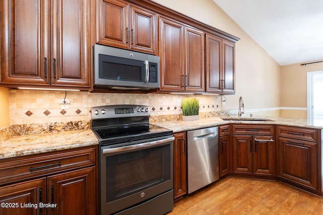 13702 Beowulf Ct, Louisville, KY 40299 - kitchen featuring stainless steel appliances, lofted ceiling, light wood-style floors, light stone countertops, and decorative backsplash