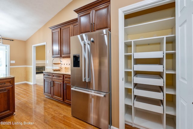 13702 Beowulf Ct, Louisville, KY 40299 - kitchen featuring high quality fridge, lofted ceiling, light wood finished floors, light stone countertops, and a wainscoted wall