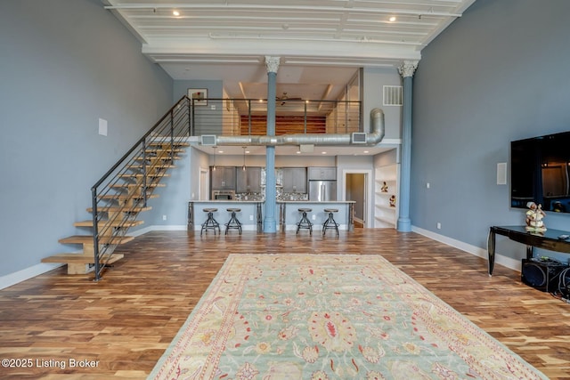 415 E Market St Unit 104, Louisville, KY 40202 - living area featuring a towering ceiling, wood finished floors, stairs, and ceiling fan