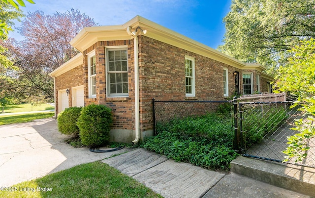606 N Arbor Dr, Louisville, KY 40223 - view of side of property with brick siding, a garage, concrete driveway, and a gate