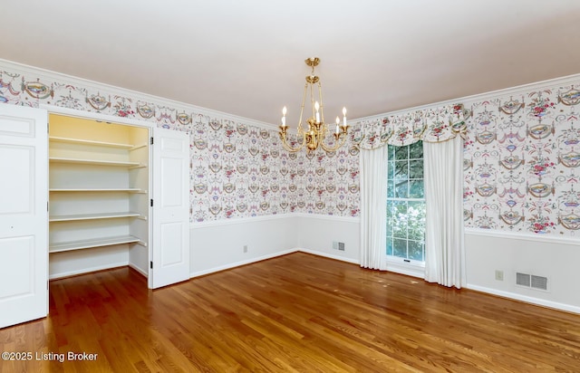 606 N Arbor Dr, Louisville, KY 40223 - unfurnished room featuring wainscoting, a chandelier, wallpapered walls, wood finished floors, and crown molding