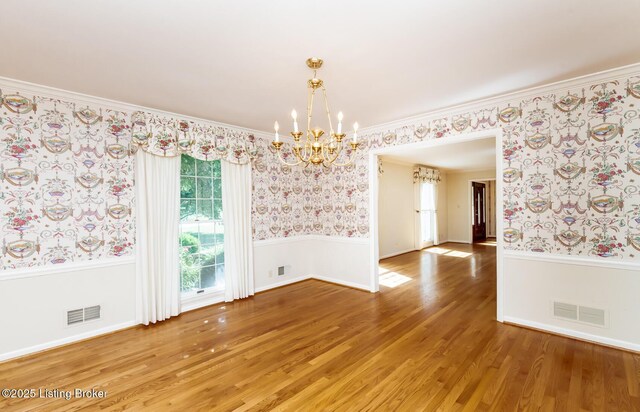 606 N Arbor Dr, Louisville, KY 40223 - spare room with wallpapered walls, a chandelier, wood finished floors, ornamental molding, and a wainscoted wall