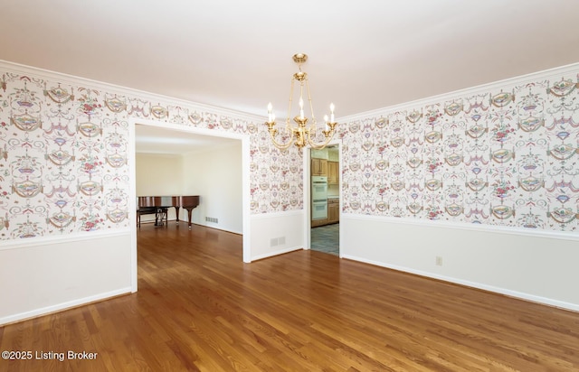 606 N Arbor Dr, Louisville, KY 40223 - spare room featuring wallpapered walls, a chandelier, wainscoting, wood finished floors, and ornamental molding