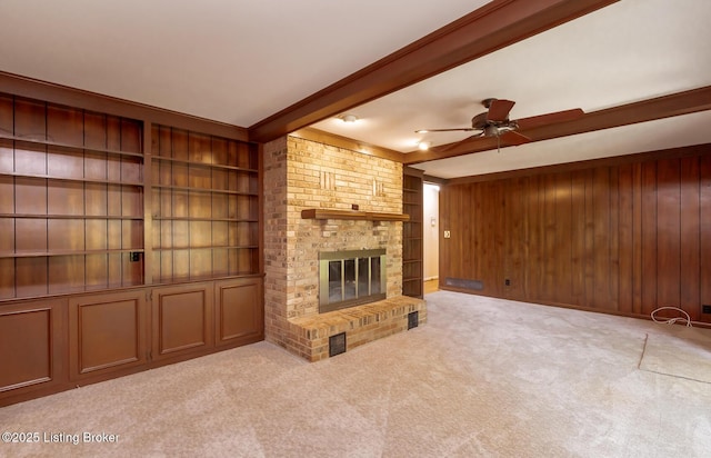 606 N Arbor Dr, Louisville, KY 40223 - unfurnished living room with wood walls, ceiling fan, carpet flooring, and a fireplace