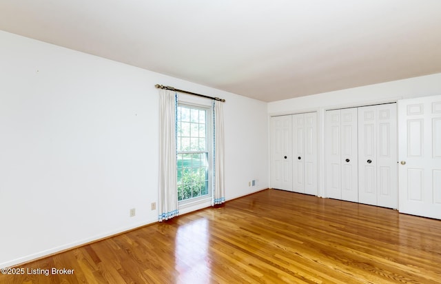 606 N Arbor Dr, Louisville, KY 40223 - unfurnished bedroom featuring light wood finished floors and multiple closets