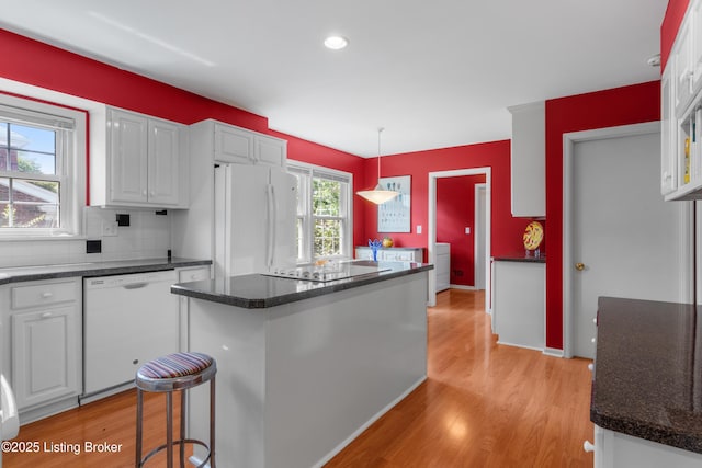 3012 Hayfield Dr, Louisville, KY 40205 - kitchen featuring white appliances, light wood-style flooring, white cabinetry, a center island, and backsplash