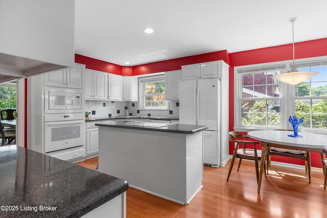 3012 Hayfield Dr, Louisville, KY 40205 - kitchen featuring white appliances, light wood-type flooring, a center island, and plenty of natural light