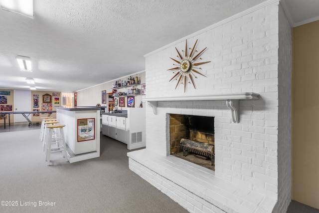 3012 Hayfield Dr, Louisville, KY 40205 - carpeted living room with a textured ceiling, a brick fireplace, bar, and ornamental molding