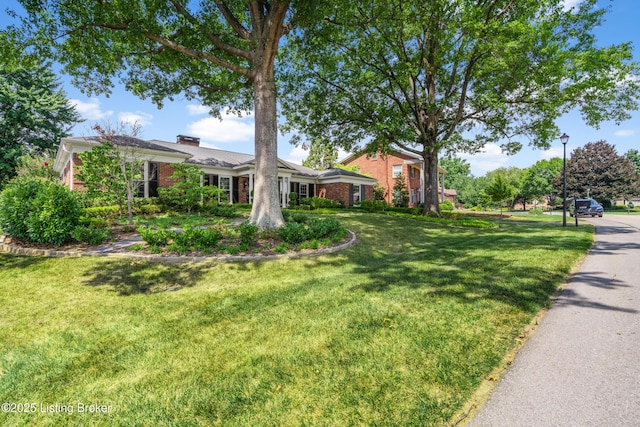 3012 Hayfield Dr, Louisville, KY 40205 - view of front of home featuring a front yard, a chimney, and brick siding