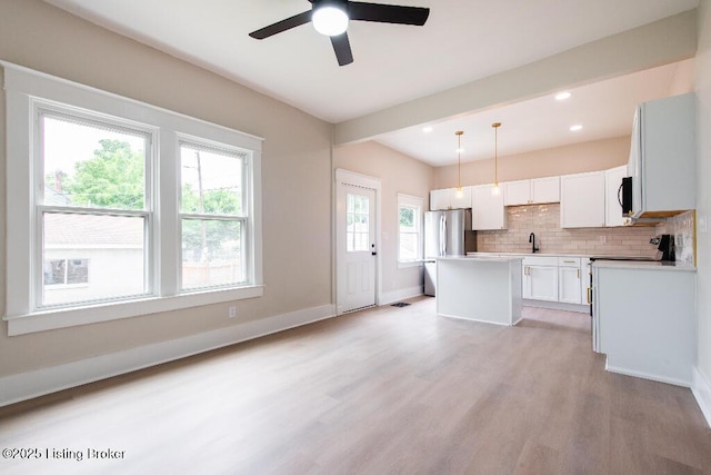 412 Gwendolyn St, Louisville, KY 40203 - kitchen with light wood-style floors, tasteful backsplash, a kitchen island, white cabinets, and pendant lighting