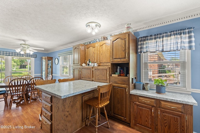 3941 Scenic Trl, Shepherdsville, KY 40165 - kitchen featuring a breakfast bar, light countertops, brown cabinetry, wood finished floors, and a textured ceiling