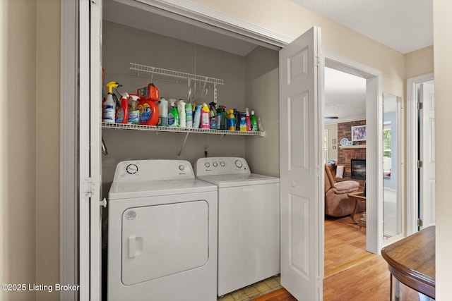 3941 Scenic Trl, Shepherdsville, KY 40165 - laundry room featuring washing machine and dryer, light wood-type flooring, and a brick fireplace