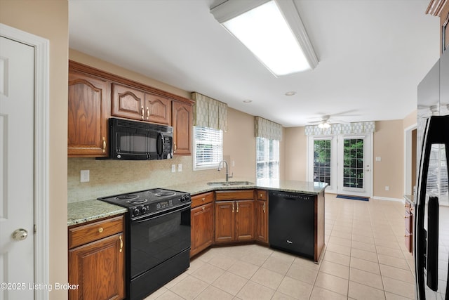 7728 Cottage Cove Way, Louisville, KY 40214 - kitchen with black appliances, a peninsula, light tile patterned floors, brown cabinetry, and decorative backsplash