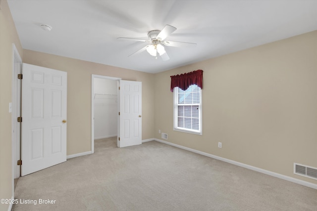 7728 Cottage Cove Way, Louisville, KY 40214 - unfurnished bedroom featuring light colored carpet, a closet, a walk in closet, and ceiling fan