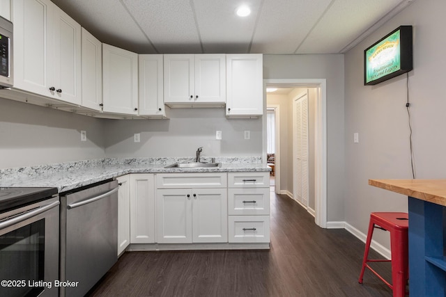1246 Ormsby Ct, Louisville, KY 40203 - kitchen featuring stainless steel appliances, white cabinetry, dark wood finished floors, and light stone countertops
