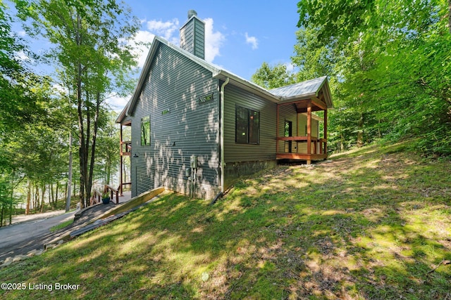 422 Lilac Ln, Cub Run, KY 42729 - view of home's exterior with a chimney, a metal roof, a yard, and a wooden deck