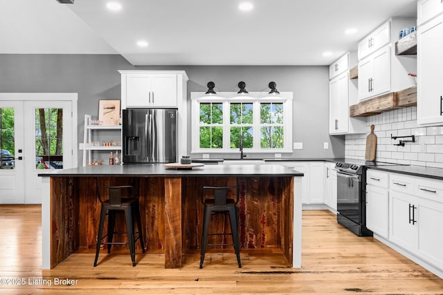 422 Lilac Ln, Cub Run, KY 42729 - kitchen with stainless steel refrigerator with ice dispenser, range with electric stovetop, dark countertops, healthy amount of natural light, and recessed lighting