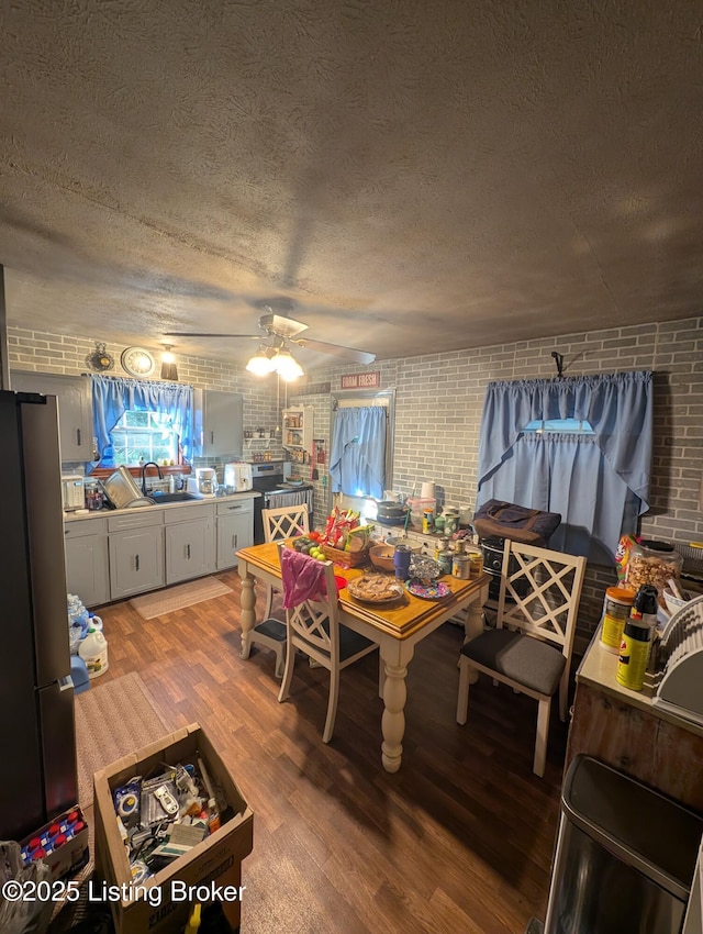118 Hardin Spring Rd, Big Clifty, KY 42712 - dining room featuring brick wall, a ceiling fan, light wood-style flooring, and a textured ceiling