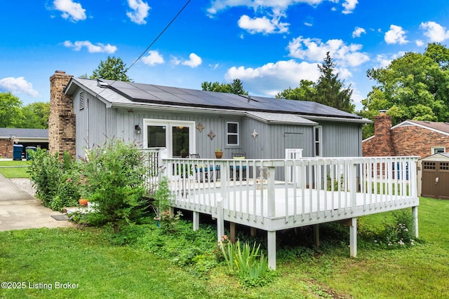 6818 Village Green Blvd, Pewee Valley, KY 40056 - rear view of property featuring roof mounted solar panels, a wooden deck, a yard, a chimney, and a storage shed