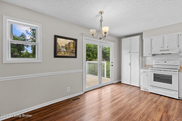 6818 Village Green Blvd, Pewee Valley, KY 40056 - kitchen featuring white range with electric stovetop, under cabinet range hood, a chandelier, light wood-style flooring, and white cabinets