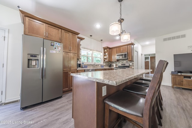 164 Greenshores Circle Ln, Mcdaniels, KY 40152 - kitchen featuring stainless steel appliances, light wood finished floors, decorative backsplash, pendant lighting, and recessed lighting