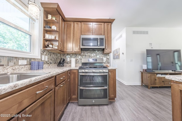 164 Greenshores Circle Ln, Mcdaniels, KY 40152 - kitchen with appliances with stainless steel finishes, wood finished floors, tasteful backsplash, and brown cabinetry