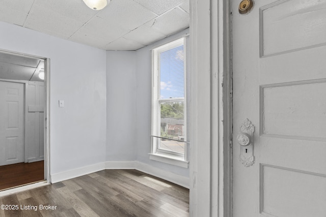 1373 Cypress St, Louisville, KY 40211 - unfurnished bedroom featuring attic access, dark wood-type flooring, multiple windows, and a drop ceiling