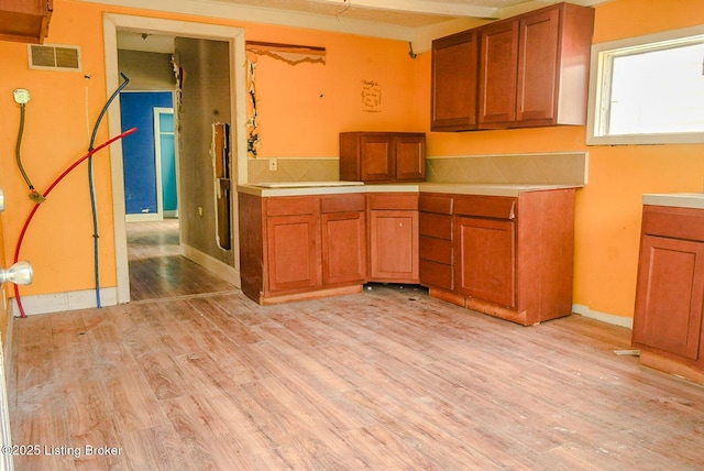 2809 Rowan St, Louisville, KY 40212 - kitchen featuring brown cabinets, light wood-style flooring, and light countertops