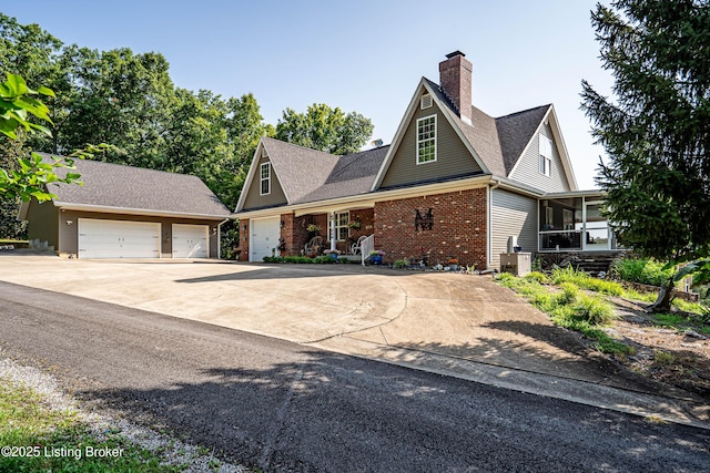 309 Clarks Ln, Clarkson, KY 42726 - traditional-style house with a sunroom, brick siding, a chimney, a detached garage, and roof with shingles