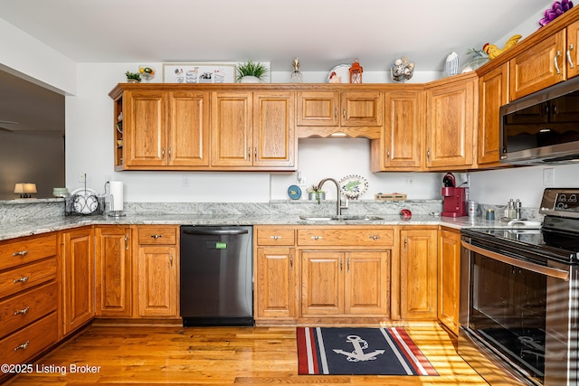 309 Clarks Ln, Clarkson, KY 42726 - kitchen with stainless steel appliances, light stone counters, light wood-style flooring, and brown cabinetry