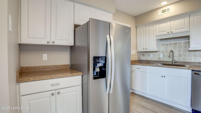 4720 Ferrer Way, Jeffersontown, KY 40299 - kitchen with appliances with stainless steel finishes, white cabinetry, tasteful backsplash, and light wood finished floors