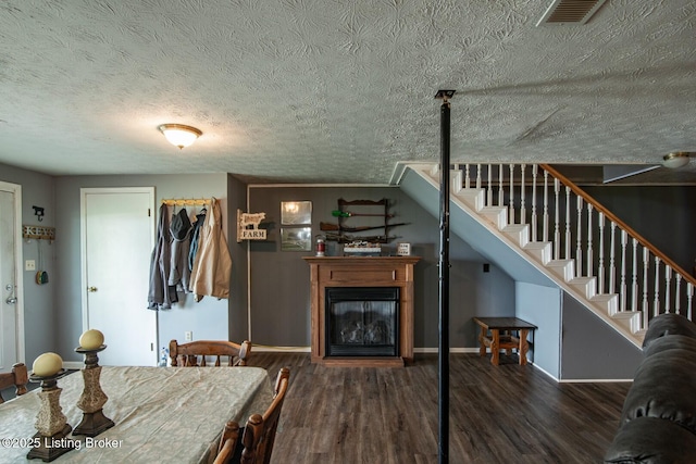 2923 High Plains Rd, Vine Grove, KY 40175 - dining space with wood finished floors, stairway, a glass covered fireplace, and a textured ceiling