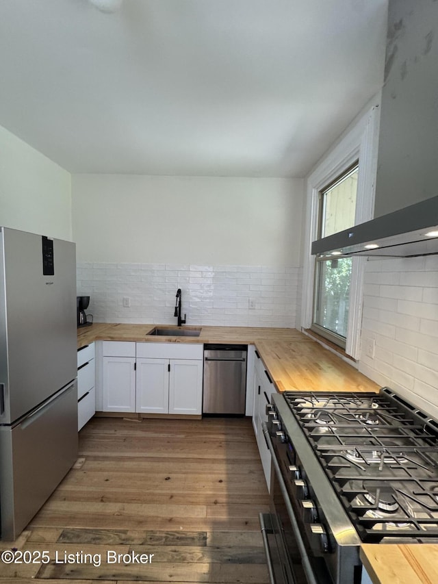 1403 S Brook St, Louisville, KY 40208 - kitchen featuring stainless steel appliances, wood counters, range hood, and white cabinetry