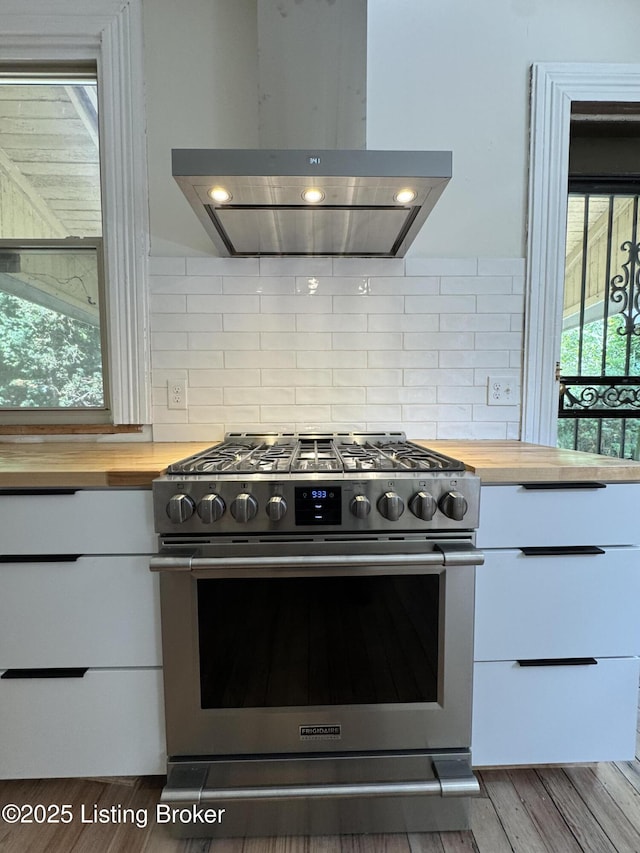 1403 S Brook St, Louisville, KY 40208 - kitchen featuring gas range, exhaust hood, butcher block counters, white cabinetry, and decorative backsplash