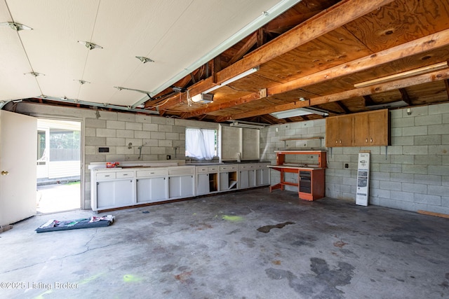 7502 Sam Ct, Louisville, KY 40214 - garage featuring a garage door opener, concrete block wall, and a workshop area