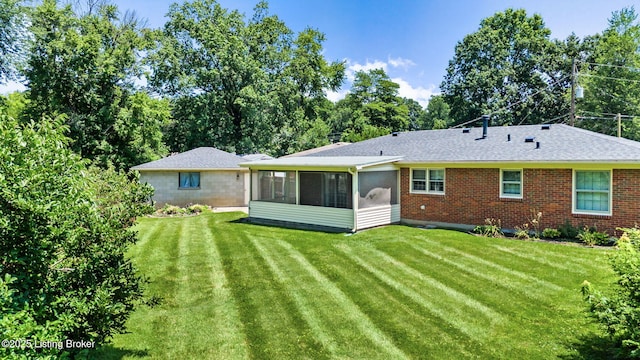 7502 Sam Ct, Louisville, KY 40214 - back of property featuring a sunroom, a lawn, brick siding, and roof with shingles