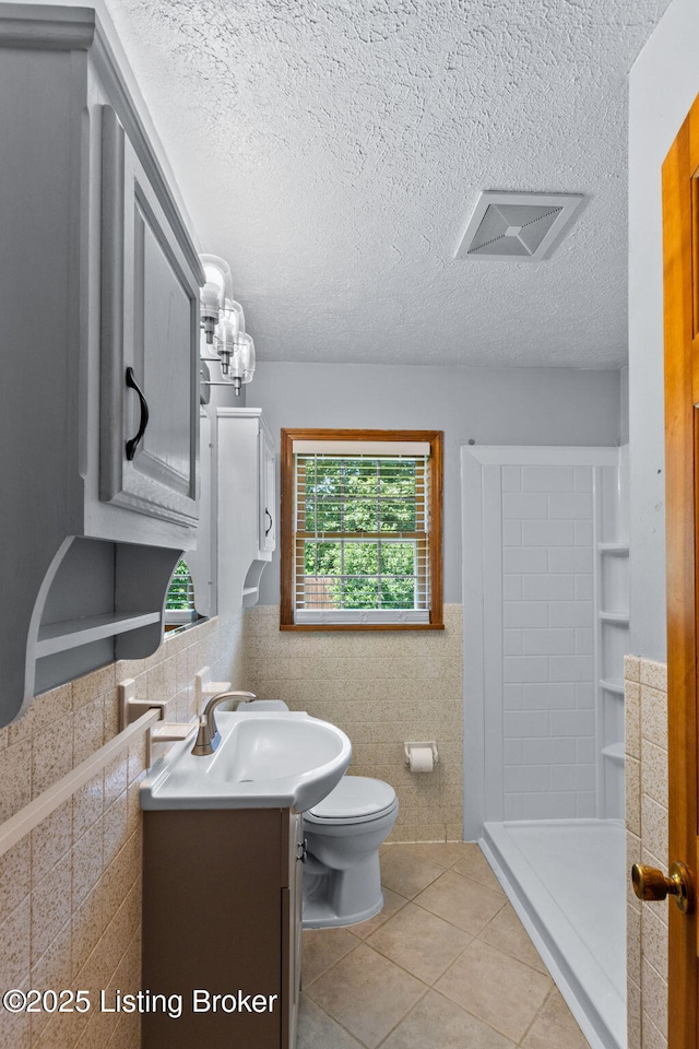 7502 Sam Ct, Louisville, KY 40214 - full bath with tile walls, vanity, tile patterned flooring, a shower stall, and a textured ceiling
