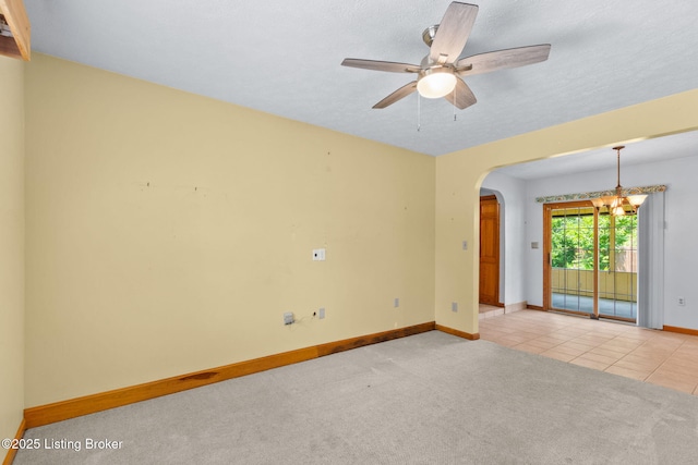 7502 Sam Ct, Louisville, KY 40214 - tiled empty room featuring arched walkways, a chandelier, carpet, and ceiling fan