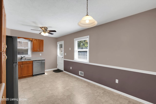 8313 Daverman Dr, Louisville, KY 40228 - kitchen featuring stainless steel dishwasher, freestanding refrigerator, brown cabinetry, ceiling fan, and light countertops