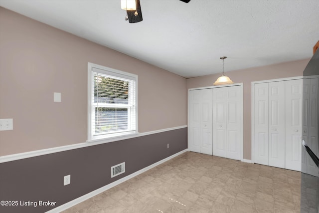 8313 Daverman Dr, Louisville, KY 40228 - unfurnished bedroom featuring multiple closets and a ceiling fan