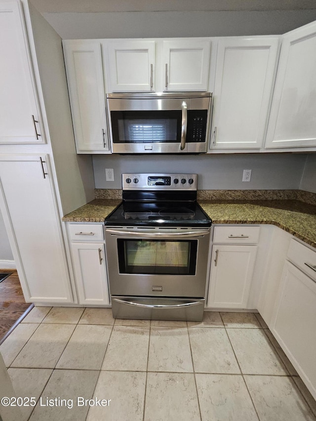 3919 Staebler Ave, Louisville, KY 40207 - kitchen with appliances with stainless steel finishes, white cabinets, light tile patterned flooring, and dark stone counters