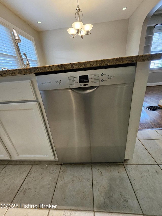 3919 Staebler Ave, Louisville, KY 40207 - kitchen view of stainless steel dishwasher, arched walkways, white cabinetry, dark stone countertops, and a chandelier