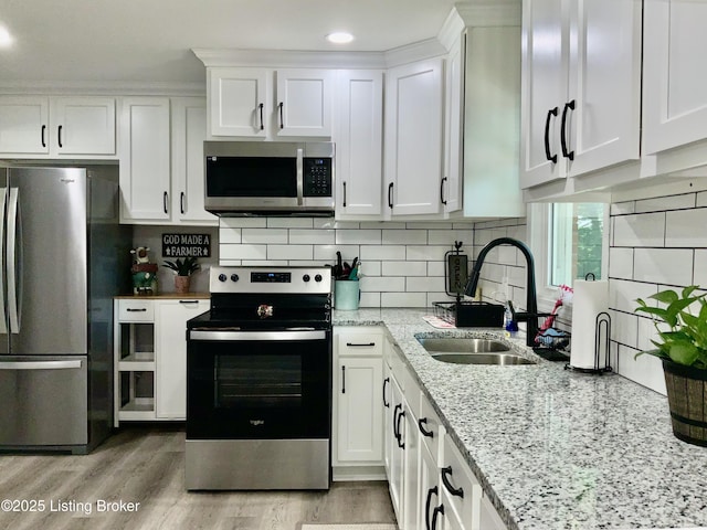 444 Lagrange Rd, New Castle, KY 40050 - kitchen with appliances with stainless steel finishes, white cabinets, light stone countertops, light wood-style floors, and decorative backsplash
